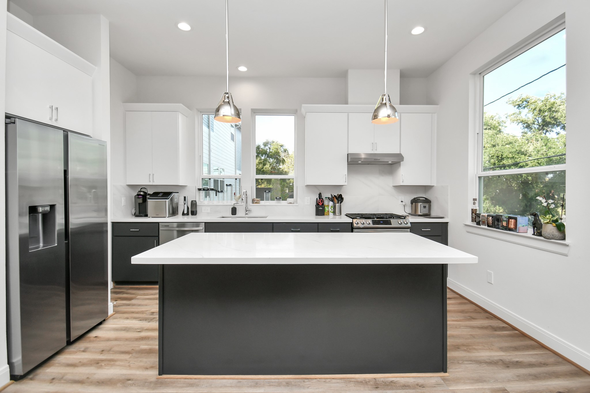 1905 Maury Street, Unit A Houston, TX 77026 - Photo 19 of 44 a large kitchen with kitchen island a large counter space a sink appliances and cabinets