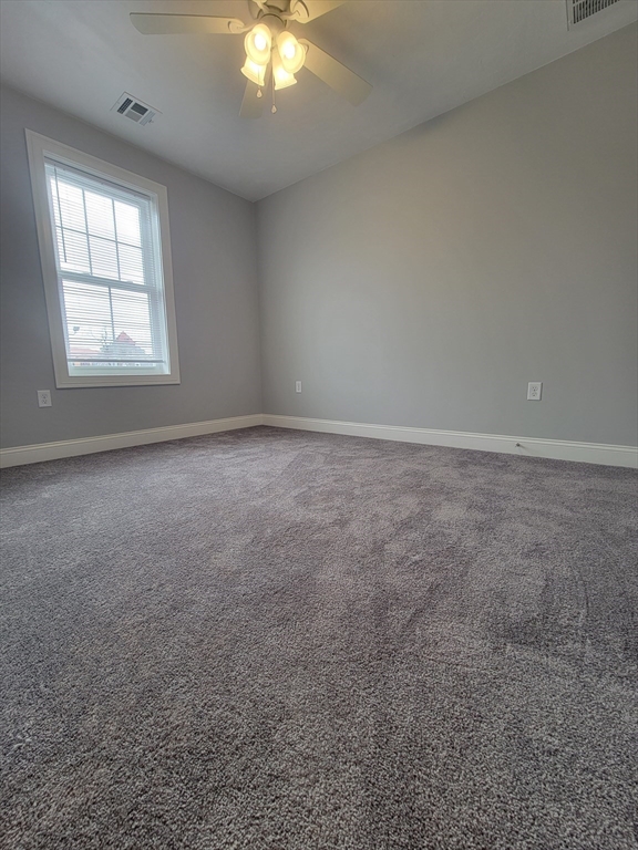 55 Arlington Street, Unit 7 Brockton, MA 02301 - Photo 18 of 37 en empty room with windows and chandelier fan