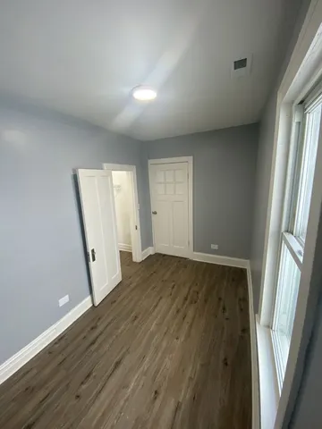 an empty room with wooden floor and window