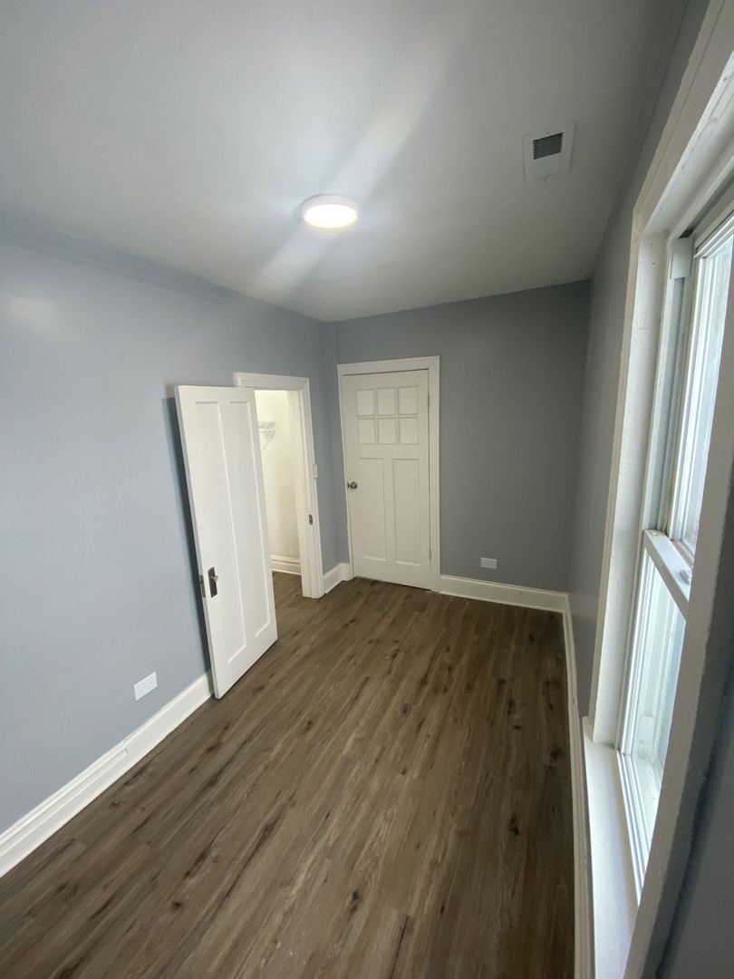 4812 South Elizabeth Street, Unit 2R Chicago, IL 60609 - Photo 11 of 14 an empty room with wooden floor and window