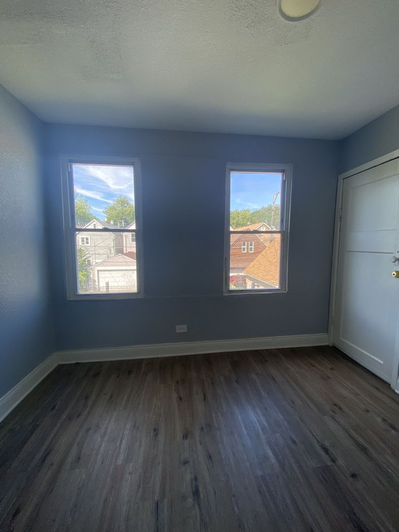 4812 South Elizabeth Street, Unit 2R Chicago, IL 60609 - Photo 12 of 14 an empty room with wooden floor and windows