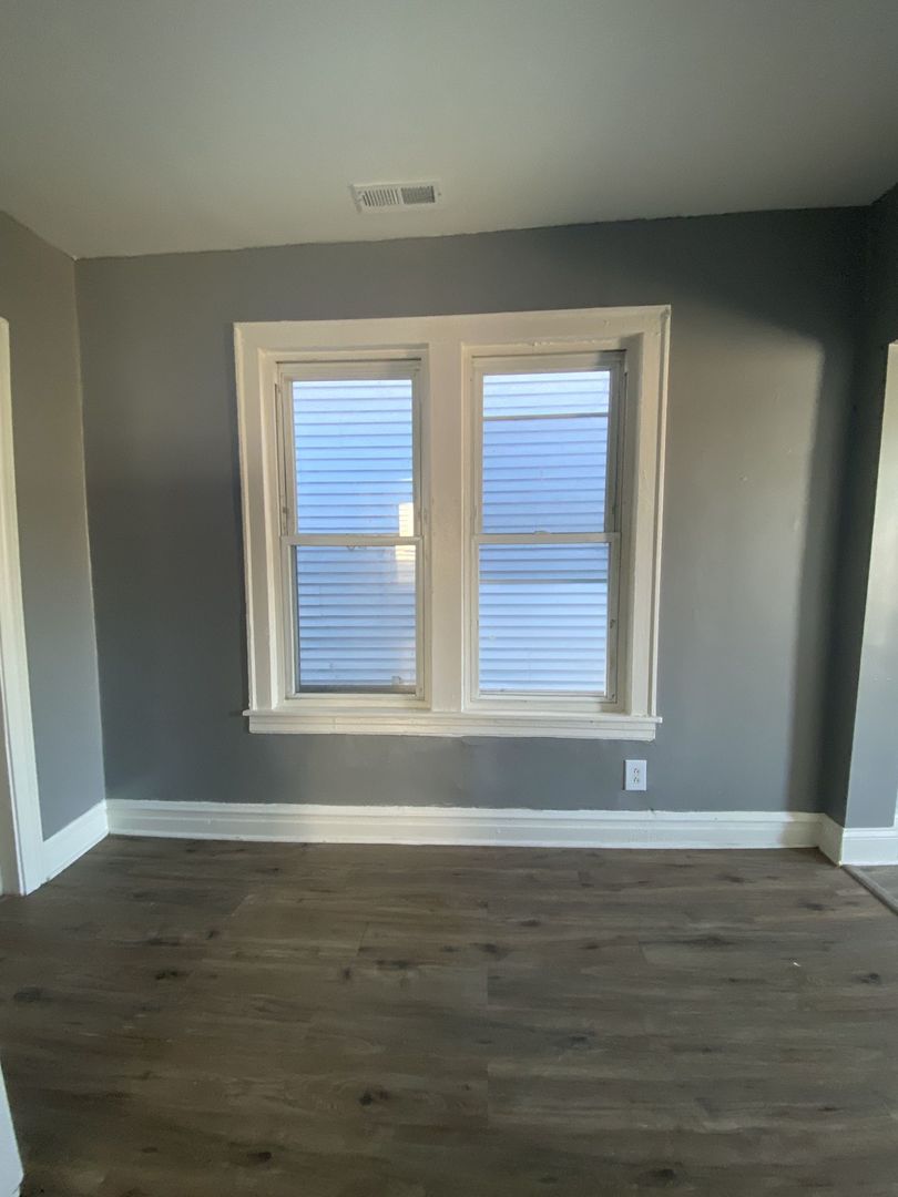 4812 South Elizabeth Street, Unit 2R Chicago, IL 60609 - Photo 13 of 14 a view of an empty room with wooden floor and a window