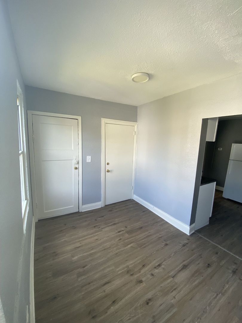 4812 South Elizabeth Street, Unit 2R Chicago, IL 60609 - Photo 2 of 14 an empty room with wooden floor and windows