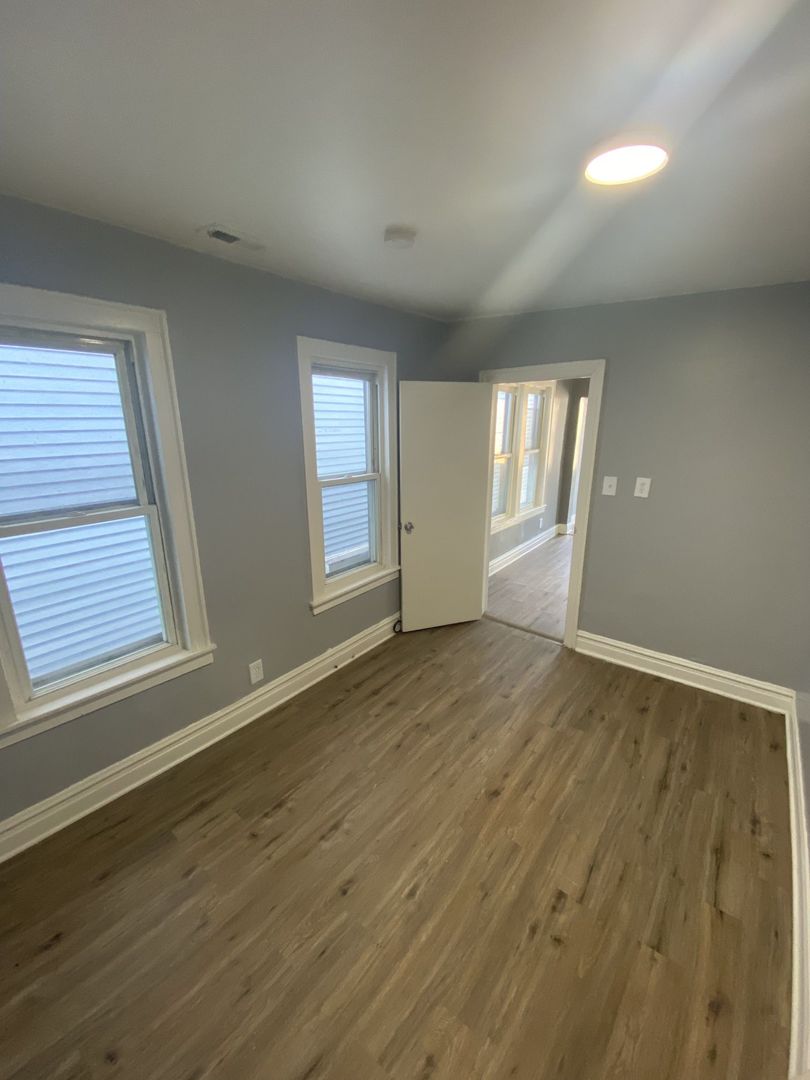 4812 South Elizabeth Street, Unit 2R Chicago, IL 60609 - Photo 10 of 14 an empty room with wooden floor and windows
