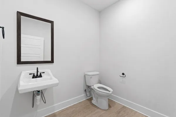 a bathroom with a toilet a sink and mirror