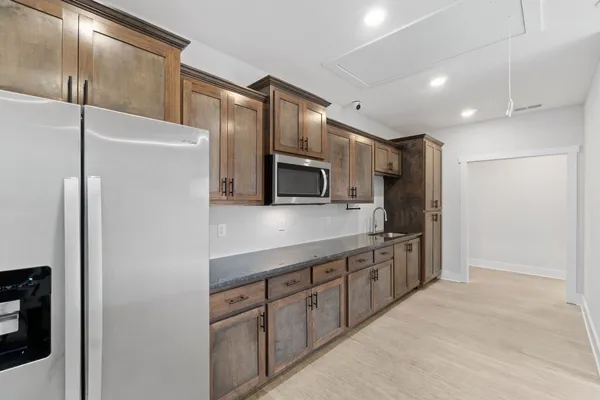 a view of a kitchen with a sink and a refrigerator
