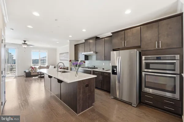 a kitchen with refrigerator and chairs