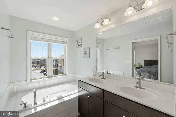 a bathroom with a tub sink and mirror