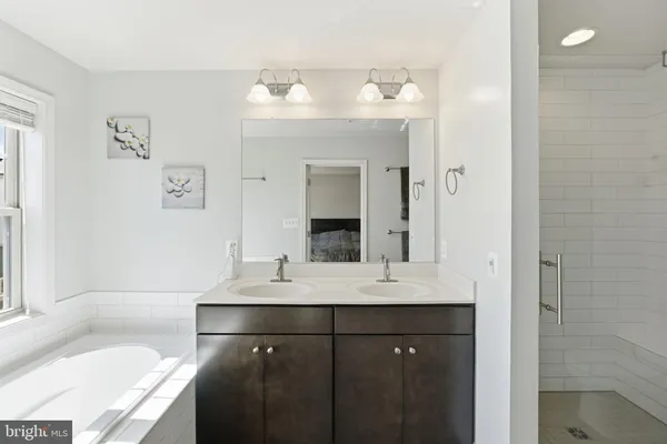 a bathroom with a sink vanity tub and a mirror