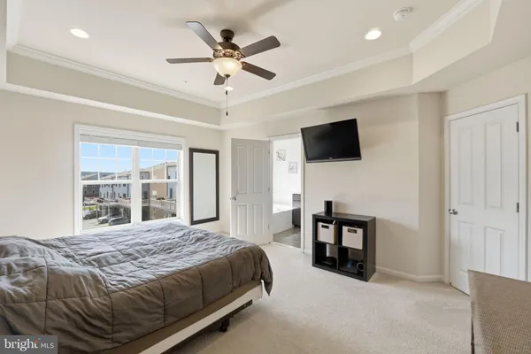 a spacious bedroom with a bed and a flat screen tv