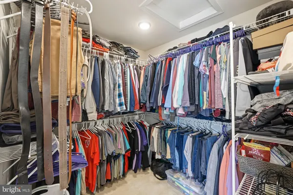 a view of walk in closet with clothes