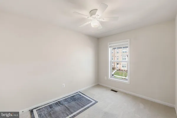 an empty room with windows and ceiling fan view