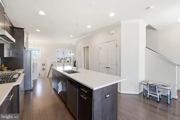 a kitchen with a kitchen island wooden floor center island and stainless steel appliances