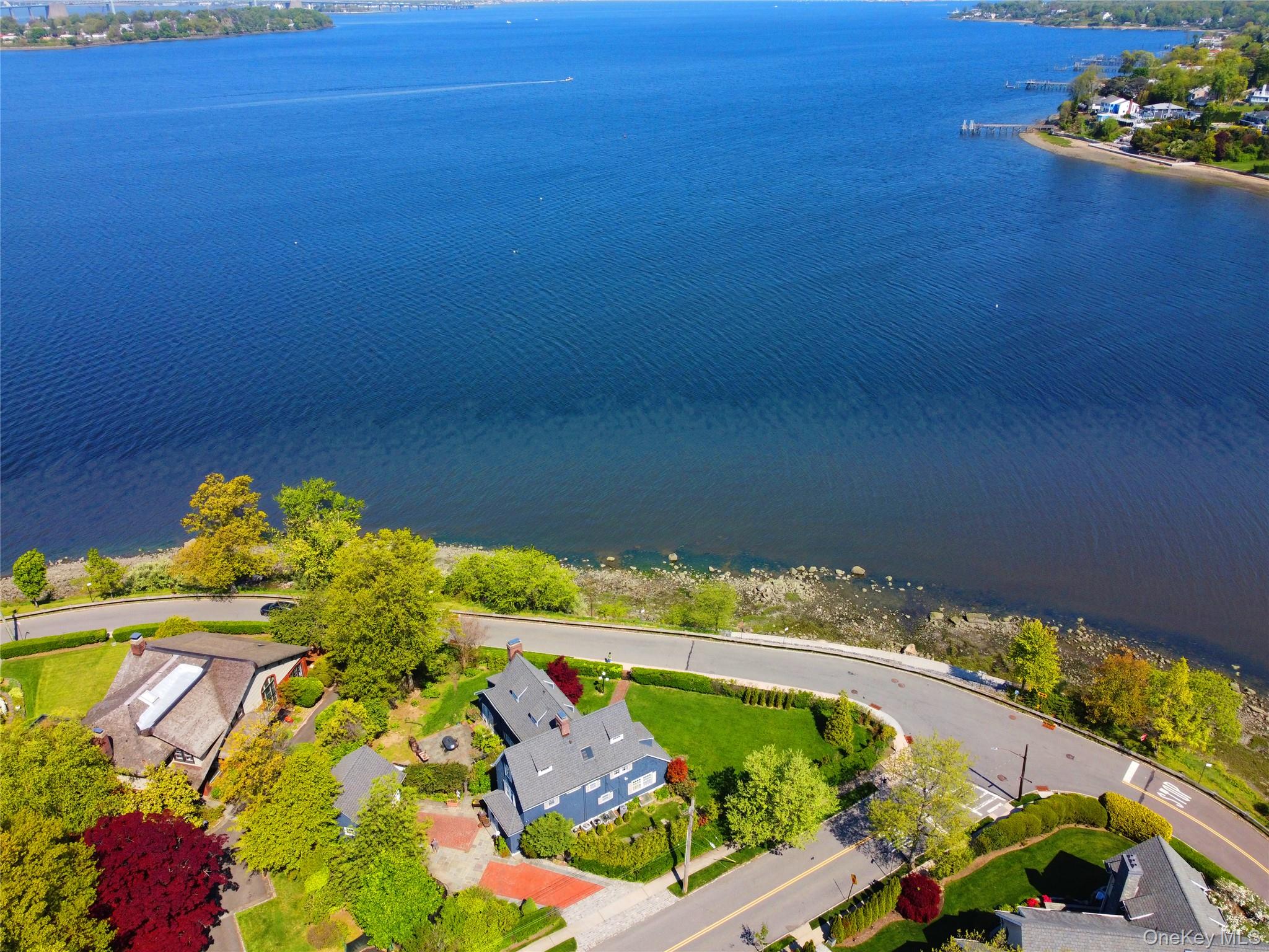 11-20 Shore Road Queens, NY 11363 - Photo 45 of 45 Waterfront property featuring a blue-sided residence, a red brick driveway, and a spacious green lawn