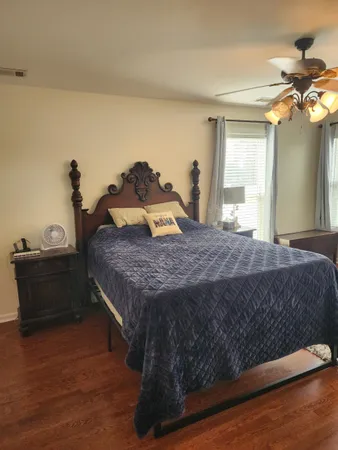 a bedroom with a bed and two windows