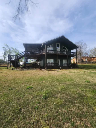 a large dining hall with stainless steel appliances granite countertop a stove oven a dining table and chairs with wooden floor