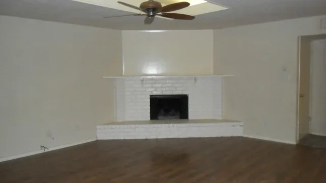 an empty room with a fireplace and fan
