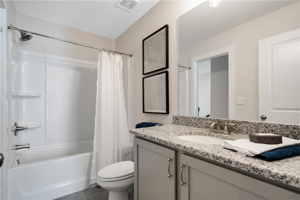 138 Torrey Pines Circle Villa Rica, GA 30180 - Photo 16 of 18 a bathroom with a granite countertop sink a toilet and shower