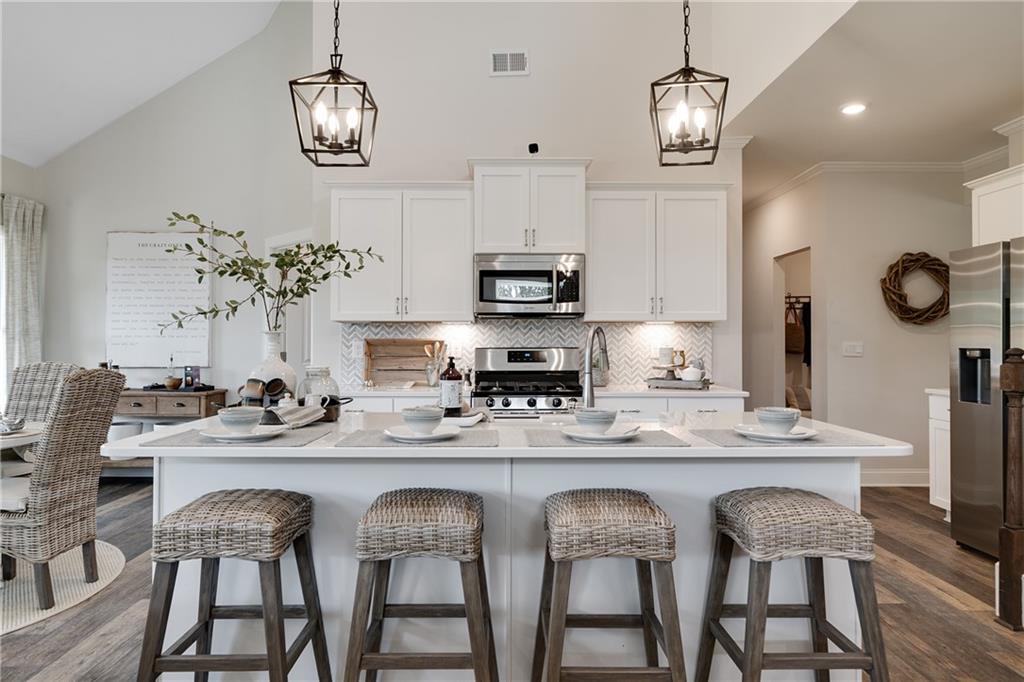 138 Torrey Pines Circle Villa Rica, GA 30180 - Photo 5 of 18 a kitchen with stainless steel appliances kitchen island granite countertop a table and chairs in it
