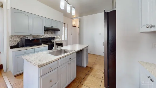 a kitchen with a sink stove and cabinets