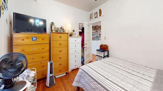 a bedroom with a bed and wooden floor