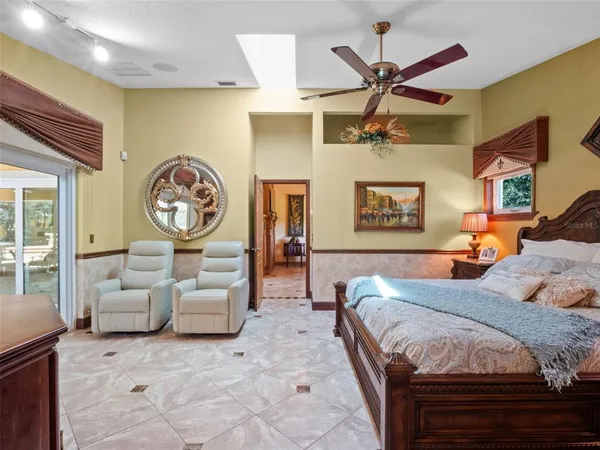 a bedroom with a large bed and a chandelier