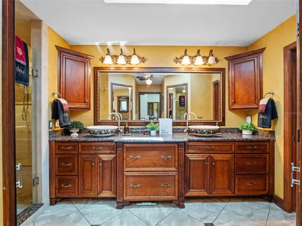 a bathroom with a granite countertop sink a mirror and a shower