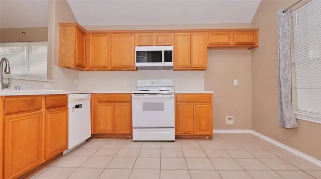 a kitchen with white cabinets and white appliances