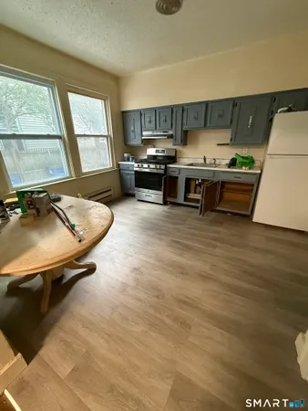 a room with stainless steel appliances kitchen island granite countertop a stove and a sink
