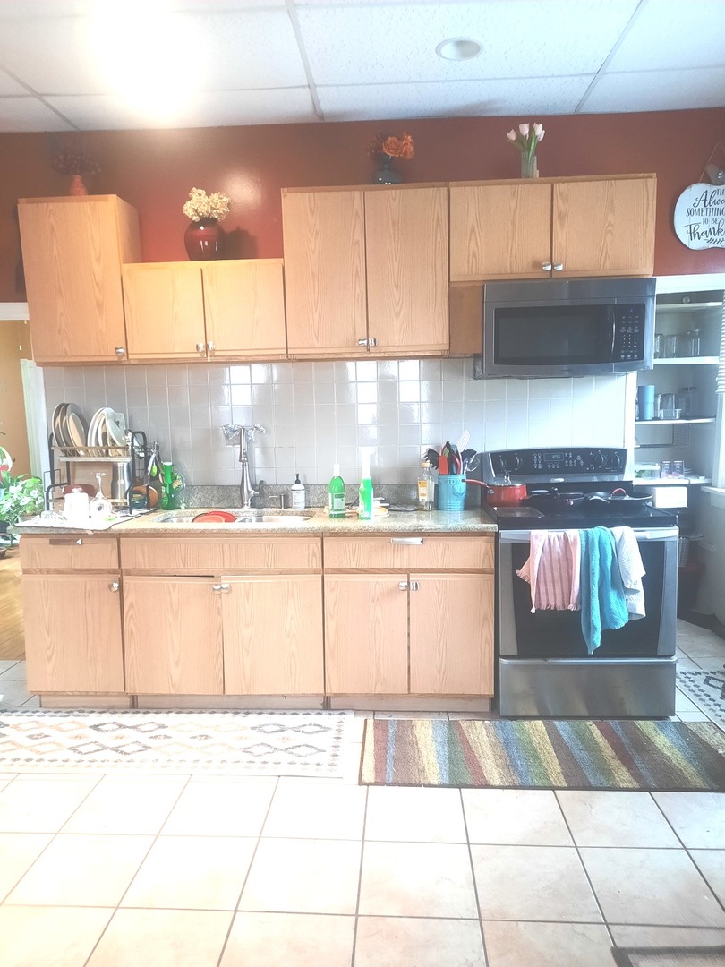 2665 East 77th Street Chicago, IL 60649 - Photo 21 of 46 a kitchen with stainless steel appliances kitchen island granite countertop a refrigerator and a stove