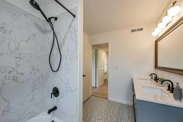 a bathroom with a sink a glass door shower and a mirror