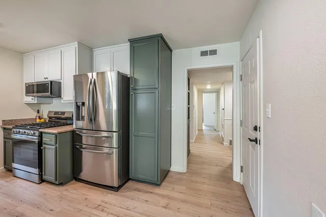 a kitchen with stainless steel appliances granite countertop a refrigerator and a stove top oven