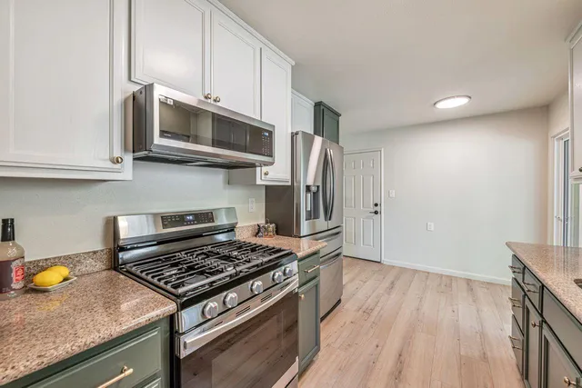 a kitchen with stainless steel appliances granite countertop a stove and a refrigerator