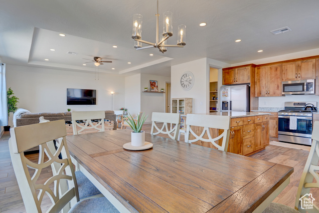 1329 Paseos Street Washington, UT 84780 - Photo 14 of 35 Dining area featuring light wood-type flooring, a tray ceiling, a chandelier, recessed lighting, and ceiling fan
