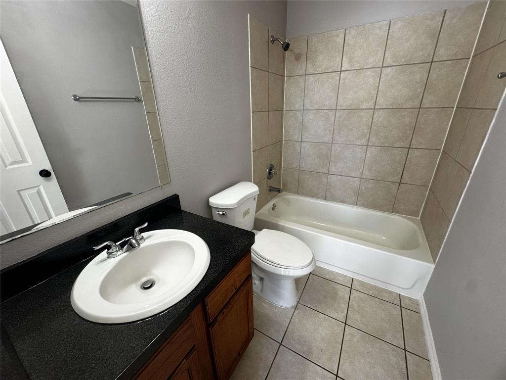 1707 Tina Marie Road, Unit A Arlington, TX 76012 - Photo 25 of 34 Full bathroom with vanity, shower / tub combination, a textured wall, and light tile patterned floors