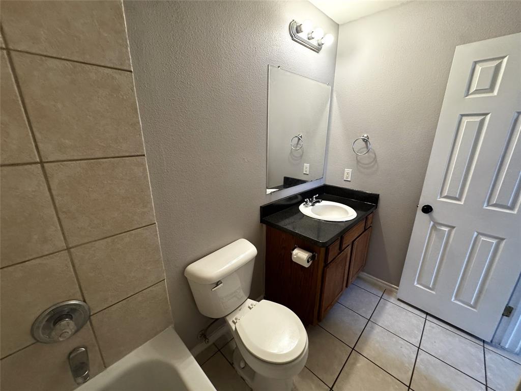 1707 Tina Marie Road, Unit A Arlington, TX 76012 - Photo 27 of 34 Full bath featuring a textured wall, vanity, light tile patterned floors, and shower / washtub combination