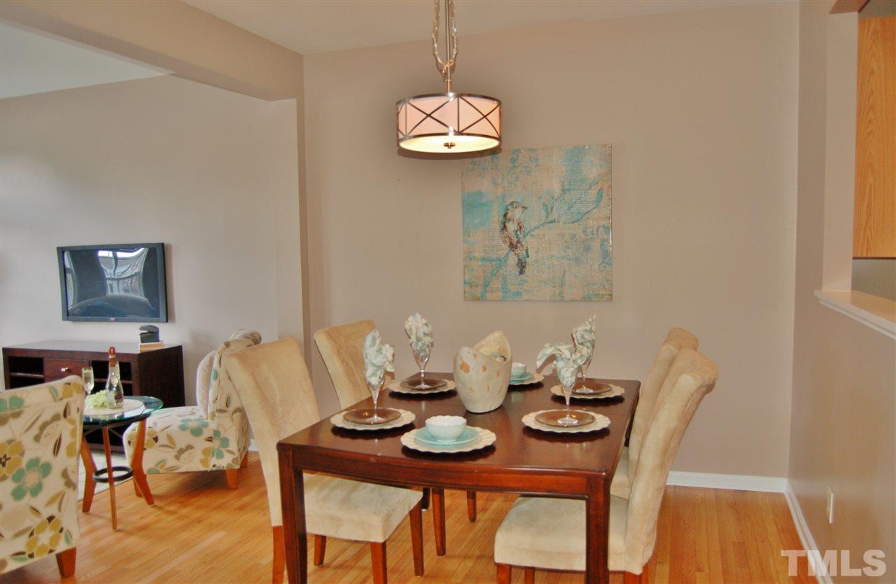 4713 Longhill Lane Raleigh, NC 27612 - Photo 4 of 18 a view of a dining room with furniture wooden floor and chandelier