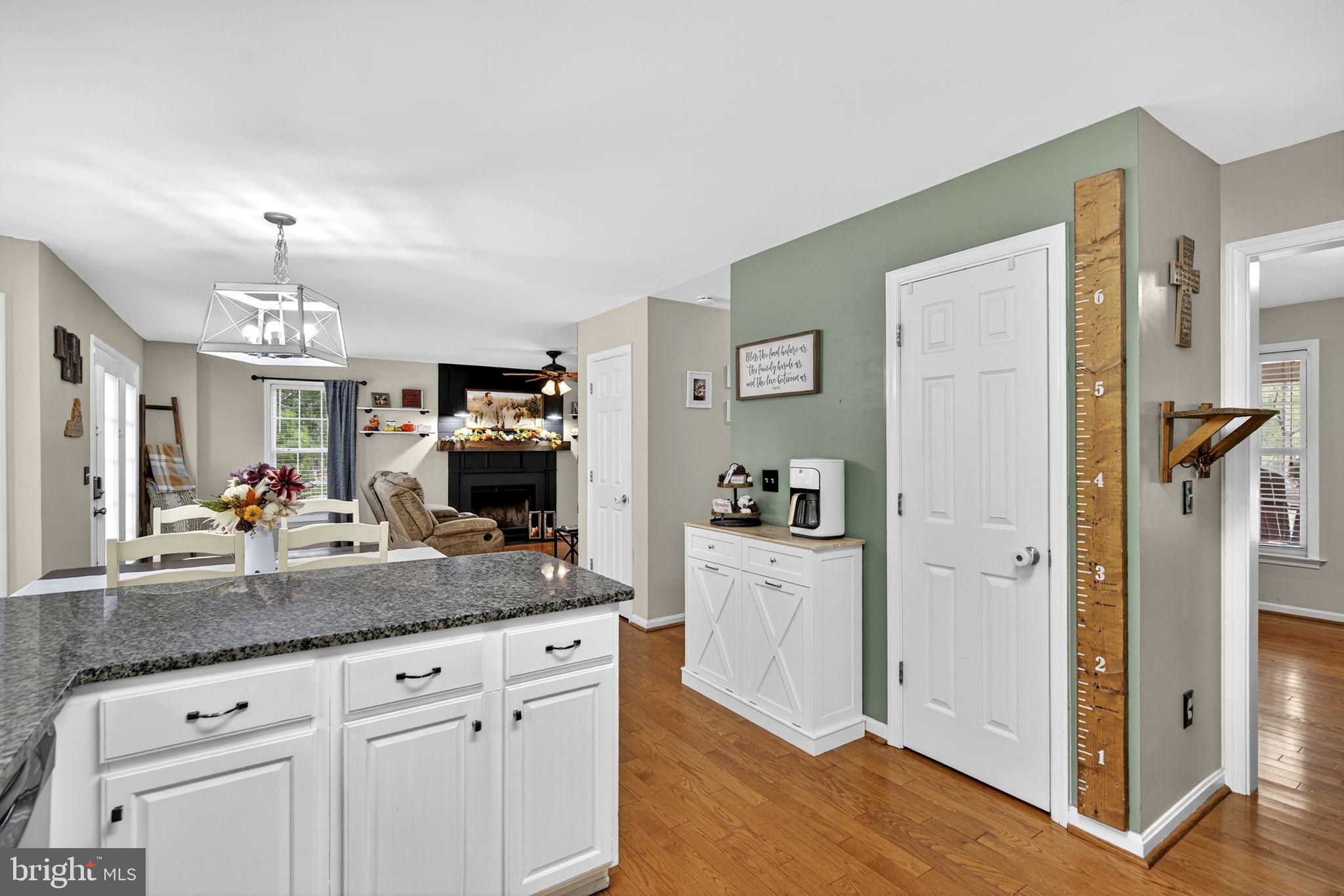 10277 River Road Rixeyville, VA 22737 - Photo 12 of 32 a kitchen with granite countertop a refrigerator a sink dishwasher and white cabinets with wooden floor