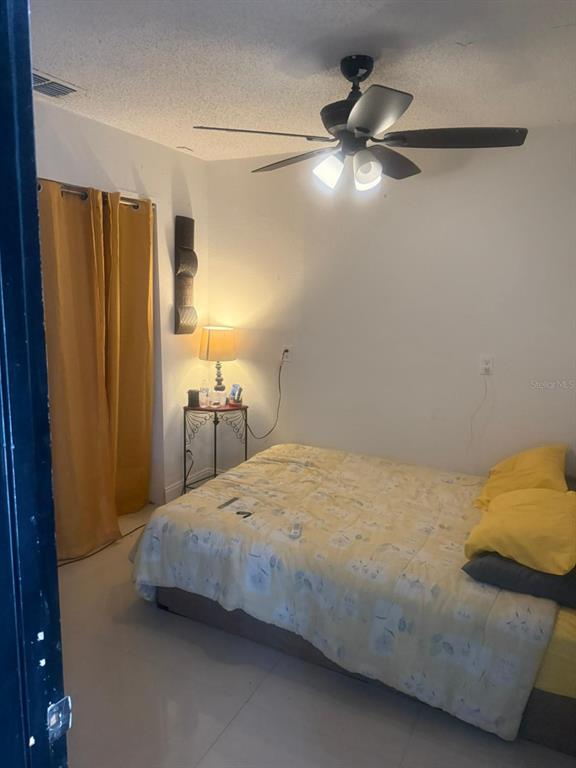 1509 Neil Street Plant City, FL 33563 - Photo 9 of 14 a bedroom with a bed and a chandelier