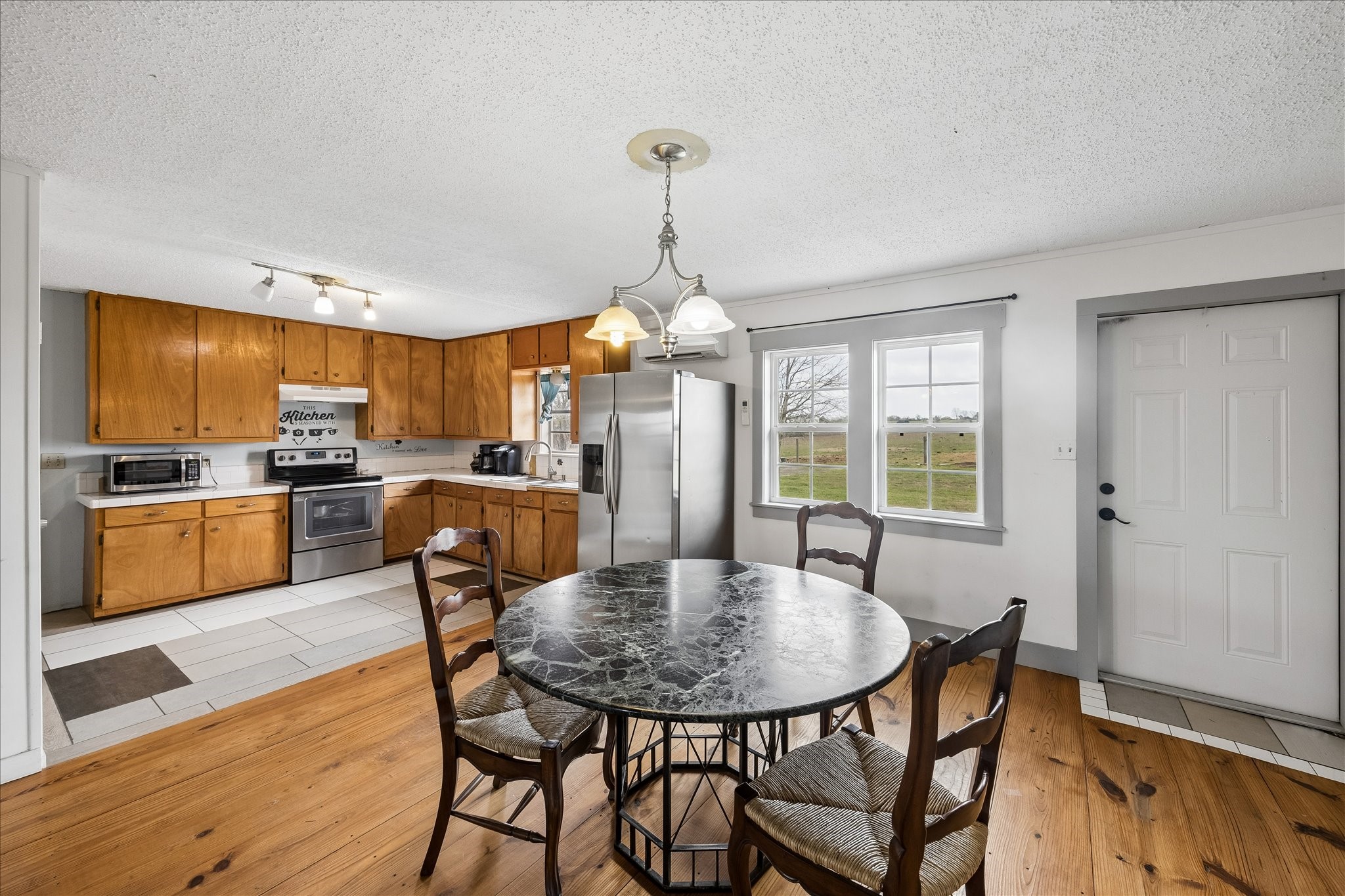 4435 Hartfield Road Round Top, TX 78954 - Photo 16 of 20 a view of a dining room with furniture window and wooden floor