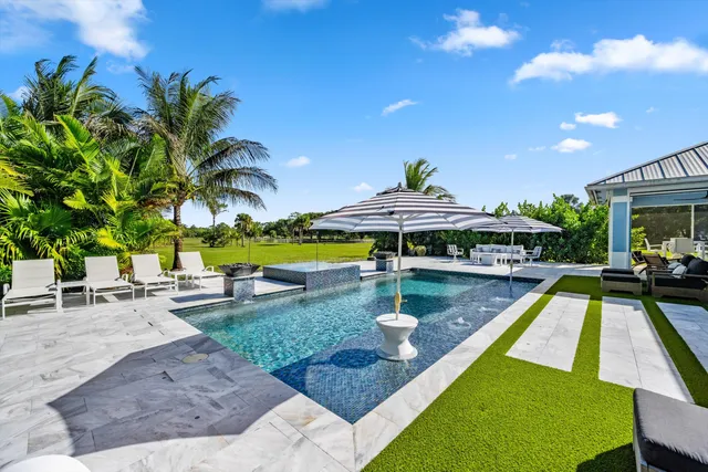 a view of a swimming pool with a patio and a yard