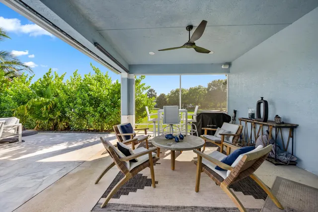 a view of a patio with couches and table and chairs with wooden fence