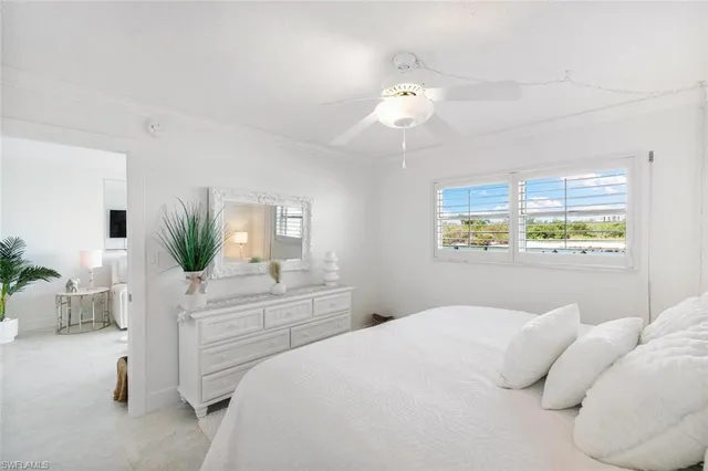 a bedroom with a bed table closet and window