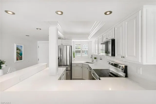 a large white kitchen with granite countertop a sink