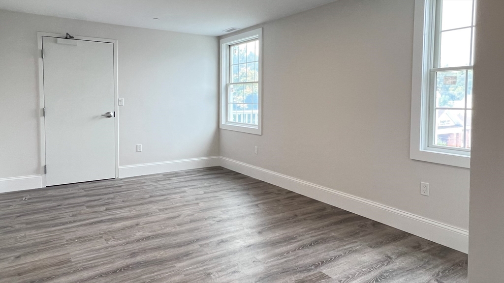 131 Cambridge Street, Unit A Burlington, MA 01803 - Photo 19 of 22 a view of an empty room with wooden floor and a window