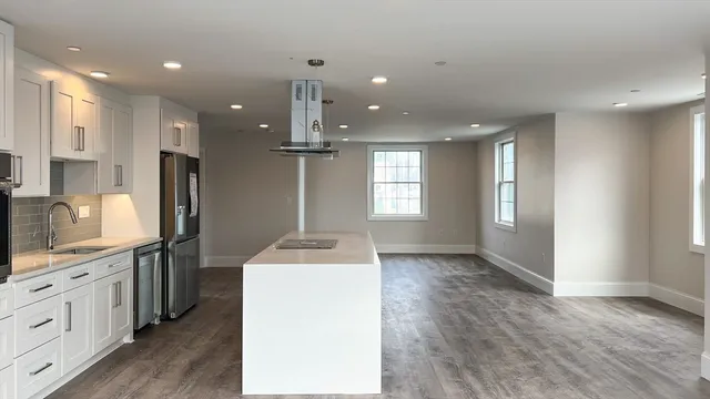 a kitchen with kitchen island sink stove and refrigerator