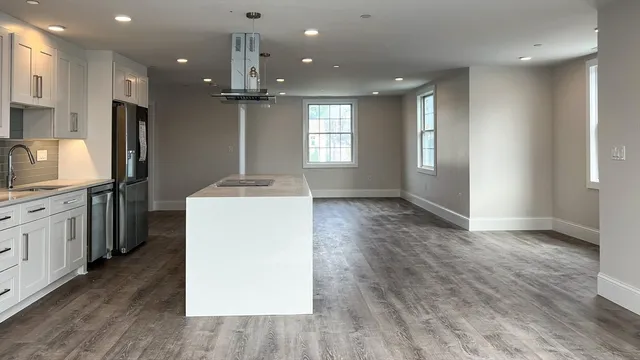 a kitchen with kitchen island a sink stainless steel appliances and cabinets