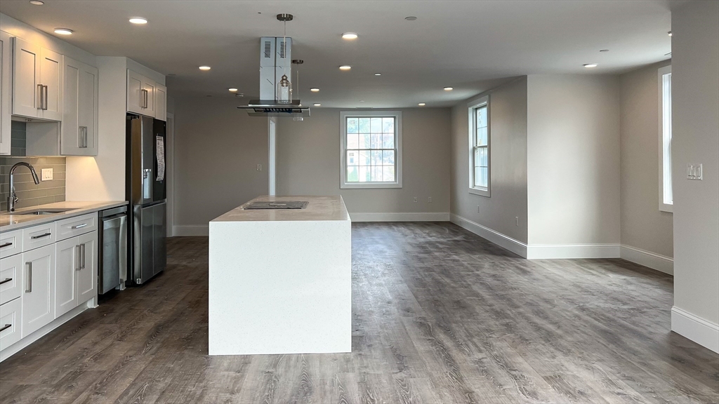 131 Cambridge Street, Unit A Burlington, MA 01803 - Photo 6 of 22 a kitchen with kitchen island a sink stainless steel appliances and cabinets