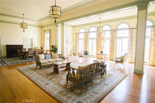 a view of a dining room and livingroom with furniture wooden floor a chandelier