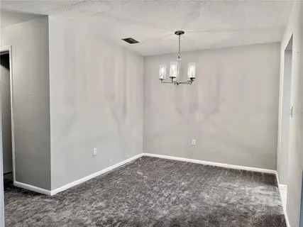 a view of empty room with chandelier fan
